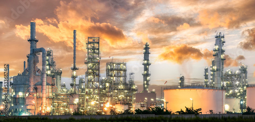 Close-up shot of oil and gas refinery Device details Steel oil pipeline with valve from a large oil storage tank in the sunset sky-image