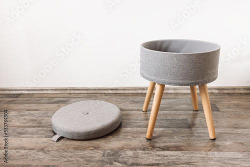 Trendy stool with and build-in storage. Side view, white wall, space