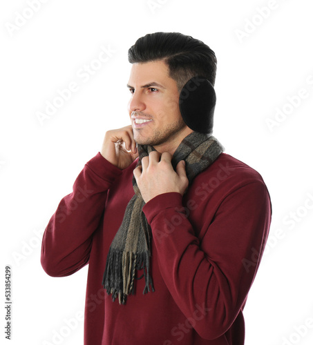 Man wearing stylish earmuffs and scarf on white background