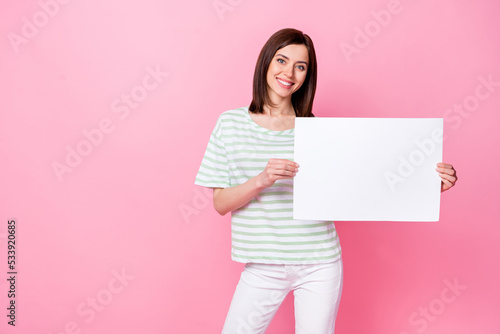 Photo of pretty satisfied lady trendy striped outfit arm hold cool proposition recommend quality product isolated on pink color background