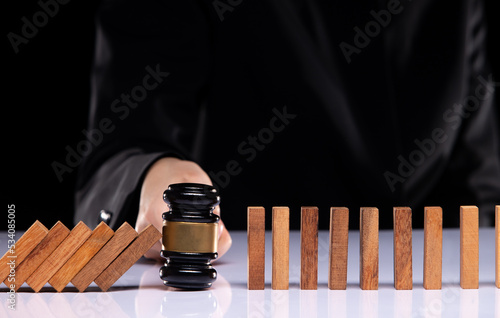 Judge gavel hand stop domino continuous tipping risk. Law crisis and crime increase stop problem falling with success effective Law enforcement and authority solving opportunity concept, copy space