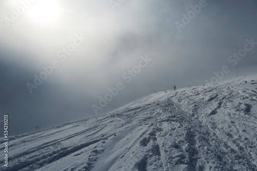 The view from the descent from the Karb Pass, High Tatra Mountains, Carpathian, Poland. Clouds and fog, a barely visible tourist. Dramatic scene. Poor visibility.