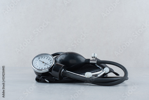 Pressure gauge with stethoscope on gray background
