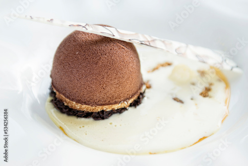 Dekoracyjny deser z dodatkiem białej czekolady na białym talerzu