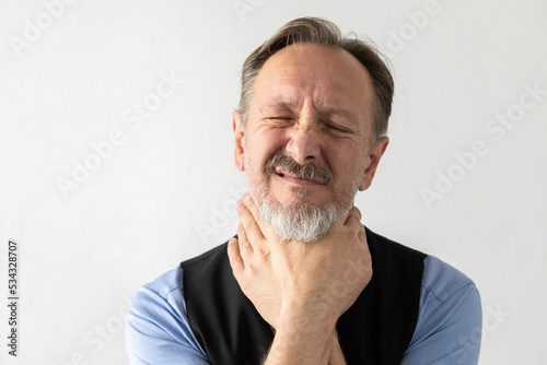 Depressed mature businessman gripping himself by throat. Portrait of senior Caucasian manager wearing formalwear choking against white background. Problem concept