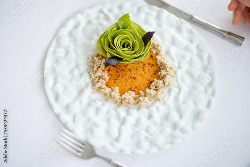 Beautiful haute cuisine vegetarian dish decorated with avocado flower, view from above