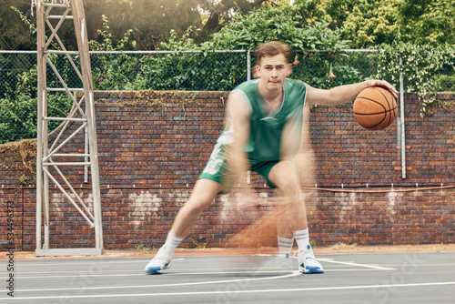 Basketball, sport and fitness with a sports man training, exercising or speed dribbling on a court with motion blur effect. Exercise, workout and health with a fast athlete playing a game outside