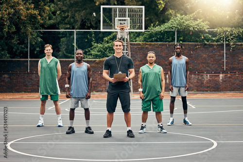Basketball, sport and team with a coach training his players on a court outdoor during summer. Teamwork, fitness and exercise with a sports group of male athletes ready for a workout or game