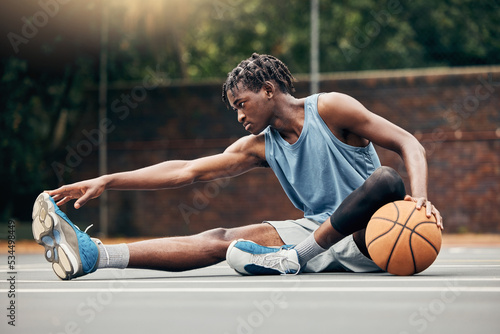 Man, basketball and training do stretching, exercise or prepare on court with sportswear. Black man, sport and ball before practice match or game in urban park for sports, fitness and physical health