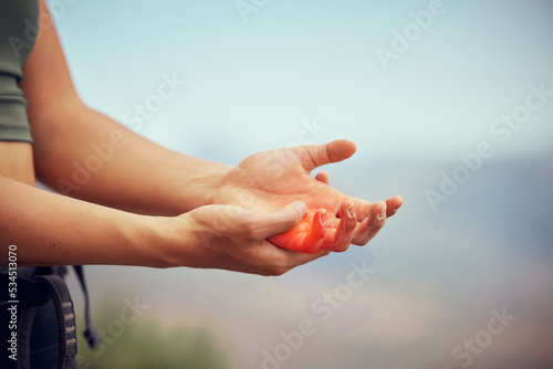 Hand injury, pain or accident of woman hiking outdoor on mountain for fitness and exercise. Closeup of injured or swollen muscle of girl athlete trekking in nature in need of emergency medical help.