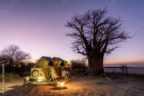 Africa - Camping in the wilderness with fire and sundowner in front of a Baobab Tree, Nxai Pan, Botswana