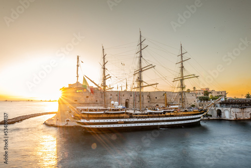 The Italian Navy Historical Ship Called Amerigo Vespucci Moored in front of the Aragonian Castle in the Canalboat of Taranto at Sunset, in the South of Italy