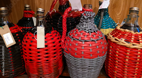 A close-up view of a demijohn with plum brandy after fresh burnt plum brandy