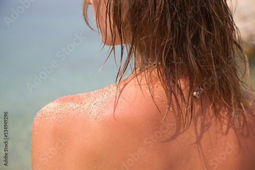 Woman's hair on the beach. Wet hair close up image. Hair damage due to salty ocean water and sun, summertime hair care concept. 