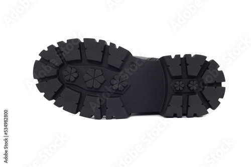 Black sole shoe , isolated on a white background. Fragment of boots with large protektor. Tread pattern on sole. Making and sale of casual shoes. Sale of shoes anti-slip protector.