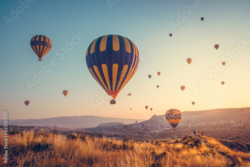 Amazing sunrise with colorful hot air balloons over spectacular Cappadocia valley. Background for your travel concept. Natural summer scenery, morning sun rise watching