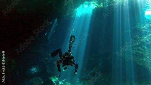 scuba diver exploring chac-mool cenote near cancun mexico