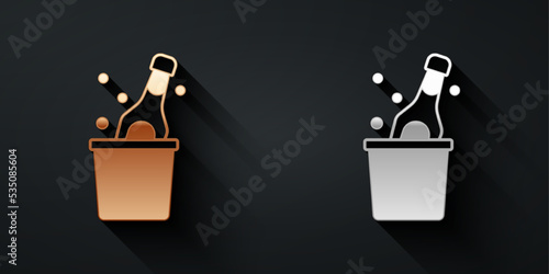 Gold and silver Bottle of champagne in an ice bucket icon isolated on black background. Long shadow style. Vector
