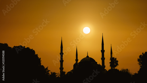 silhouette islamic mosque with dome and two tower with background of sunrising