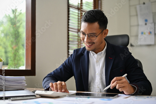 Professional and successful adult Asian businessman is working at his desk