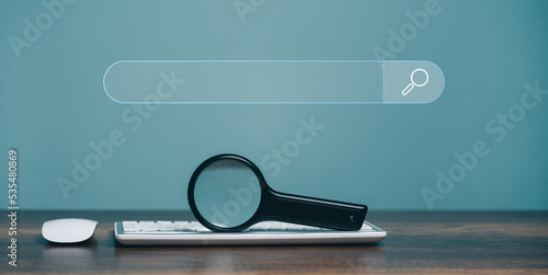 Magnifying glass keyboard computer and search bar or search box on virtual screen, browsing Internet global data Information.