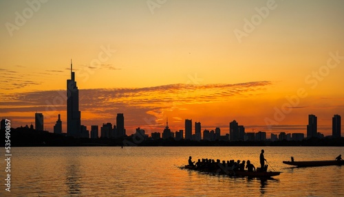 Silhouette of a tourist boat on the water of Xuanwu Lake Park, Nanjing, Jiangsu, China at sunset