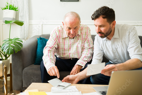 Caring son doing the finances of his elderly father