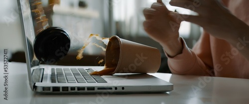 CU Caucasian female working from home, spills coffee on keyboard of her laptop