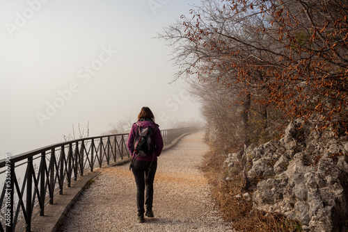 Woman walking alone on rural misty path