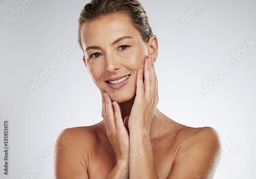 Face wellness, skincare and mature woman with smile for dermatology against a grey mockup studio background. Portrait of model for luxury cosmetic spa with natural facial skin care and mock up space