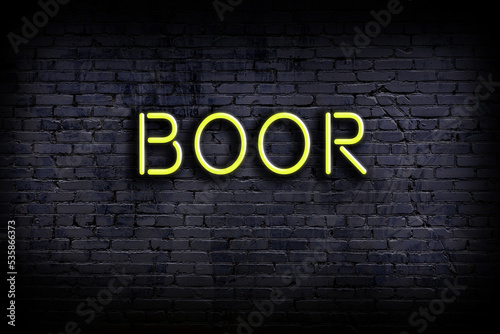 Neon sign. Word boor against brick wall. Night view