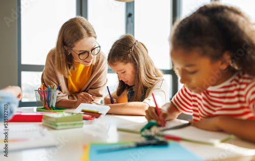 Teacher helping children with schoolwork