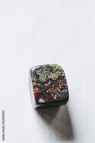 Galet pierre roulée polie jaspe sang de Dragon sur un fond blanc avec espace vide - Minéral naturel