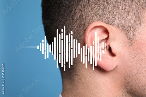 Hearing loss concept. Man and sound waves illustration on light blue background, closeup