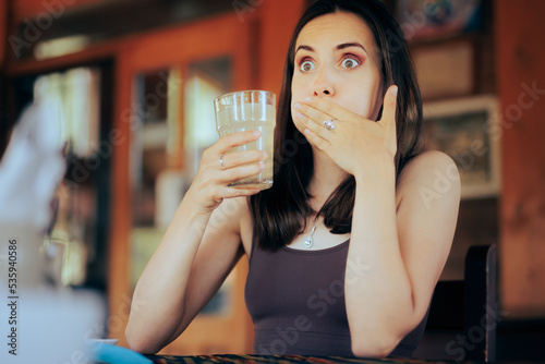 Woman Reacting after Drinking a Sour Beverage. Unhappy girl drinking a citrus beverage with a bad taste 