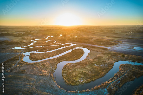 Sunrise over the meandering river. The meandering river over frozen plains. 