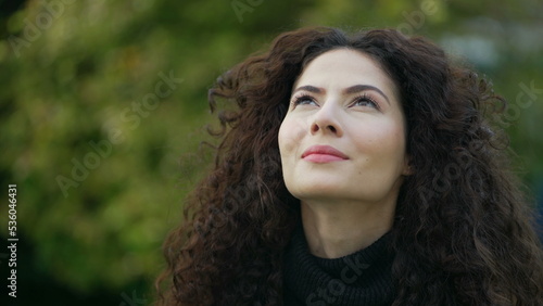 Contemplative woman face looking at sky. Mindful female person. Meditative person having HOPE standing outdoors in nature