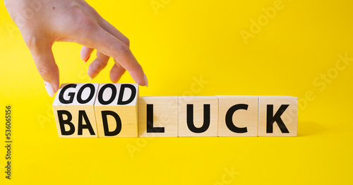 Good Luck and bad Luck symbol. Hand turns a cube and changes the words Bad Luck to Good Luck. Beautiful yellow background. Businessman hand. Business concept. Copy space