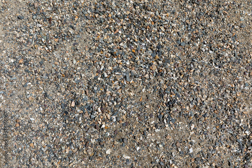 Smooth round pebbles texture background. Pebble sea beach close-up, dark wet pebble and gray dry pebble