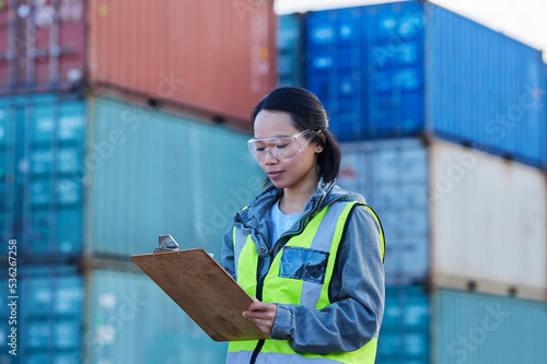 Logistics, Asian woman and check containers, export and import for supply chain at shipyard with clipboard. Female supervisor, planning or confirm storage cargo shipping, strategy and global business