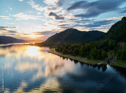 Calm Bled lake at sunrise with clouds in a sky.