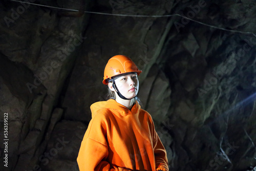 Teenage girl in a helmet in a cave