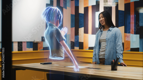 An avatar of a girl gives presentation to an asian woman through an abstract hologram screen in metaverse. Technology of digital world in parallel with the physical one. Augmented Reality.