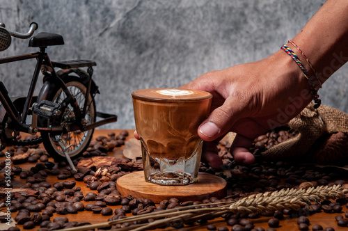Kawa espresso na drewnianym stole pełnym świeżo palonych ziaren kawy