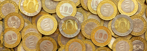 Coins of the state of Kazakhstan close-up. Kazakhstani coins of 200 and 100 tenge on a banknote. The concept of banking and inflation.