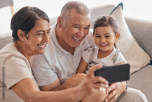 Family, grandparents and selfie on smartphone with child happy and excited to bond with relatives. Phone photograph for senior grandmother and grandpa babysitting grandchild in Mexico home.