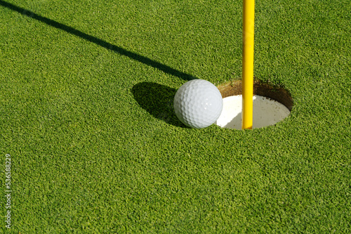 Close-up of Golf Course Green, Flag Pin and Ball.