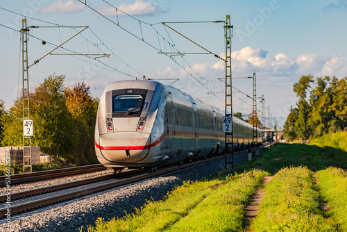 Eine Bahntrasse mit einem ICE in ländlichem Gebiet hilft bei der Mobiolitätswende im Personenverkehr, Deutschland