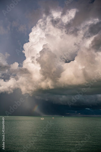 Rainbow and yacht under a storm cloud