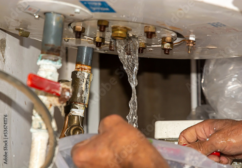 boiler Running water Leak from the home boiler. A solar boiler technician fixes a leak from the boiler
